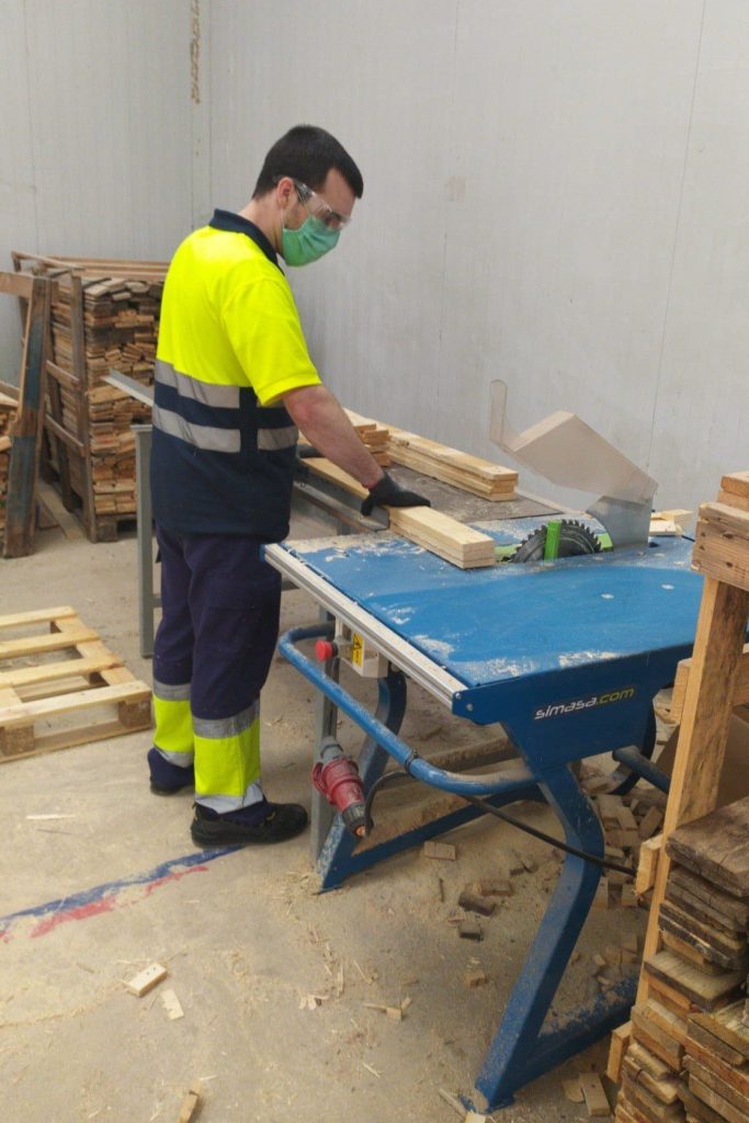 Hombre cortando madera en taller