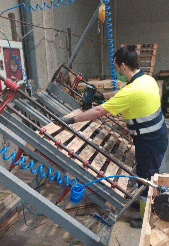 Empleado ensamblando palets de madera